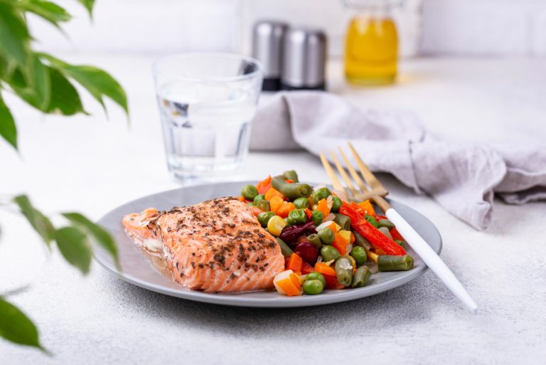A table set with a vibrant, healthy meal featuring brain-boosting foods like salmon, avocado, nuts, and berries