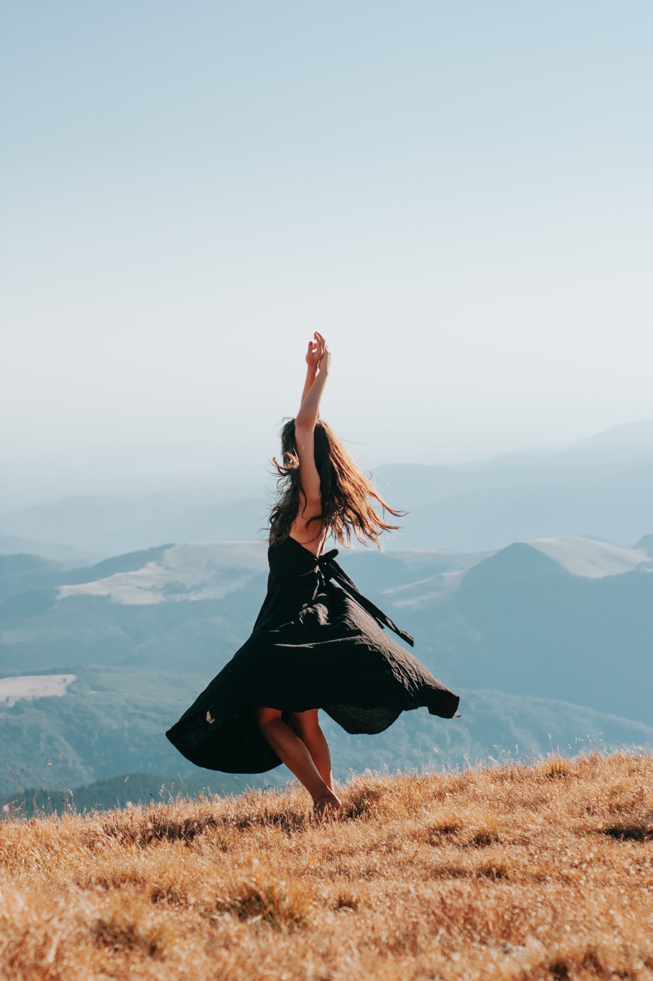 Beautiful woman dancing barefoot in the grass
