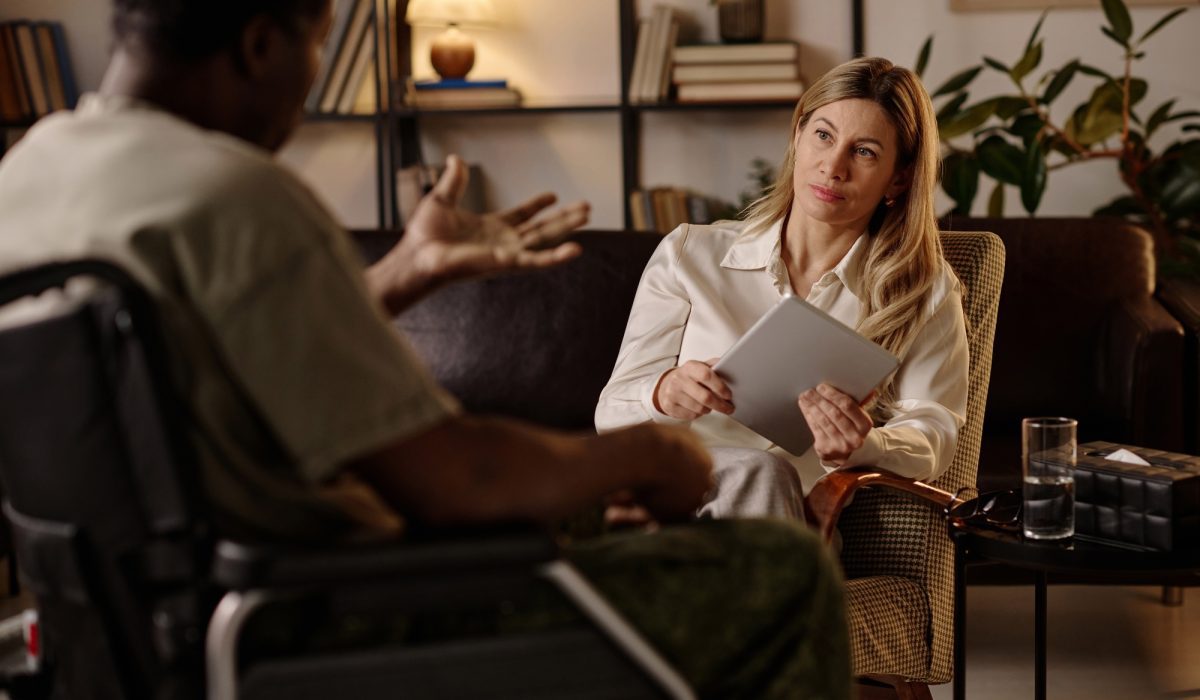 Overwhelmed female therapist surrounded by paperwork and admin tasks in her private practice office.