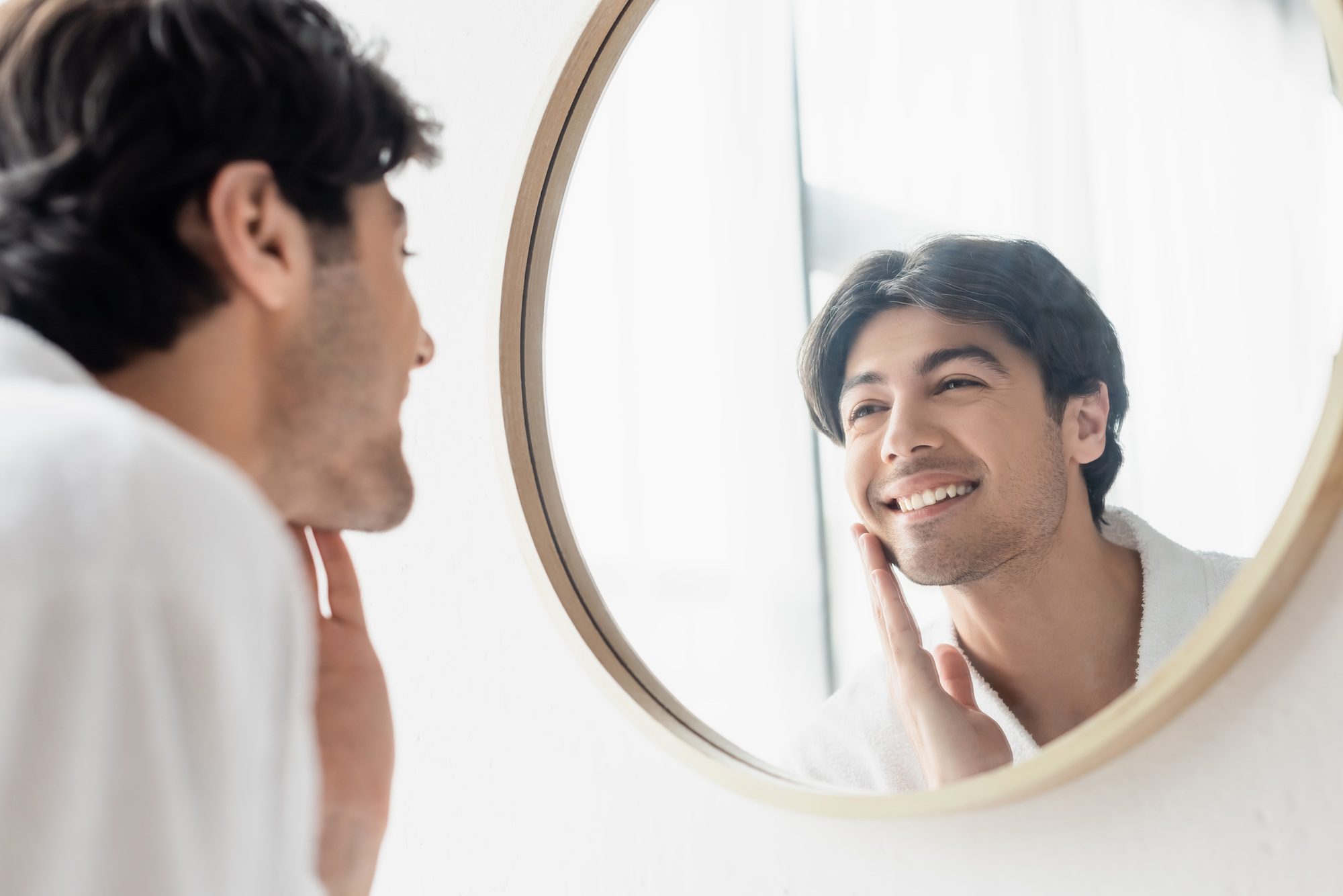 A person looking in the mirror with a confident expression, representing self-worth and inner transformation.
