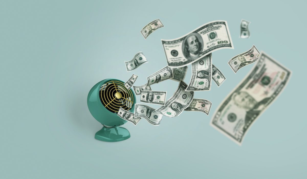 Money down the drain, concept. Losing money, a creative idea. Vintage fan blowing