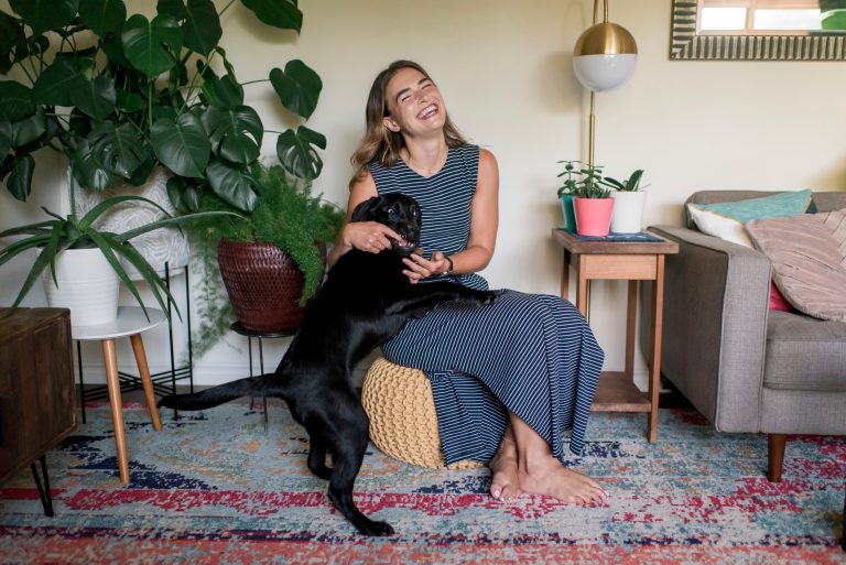 A serene, cozy setting with a person smiling with their dog.